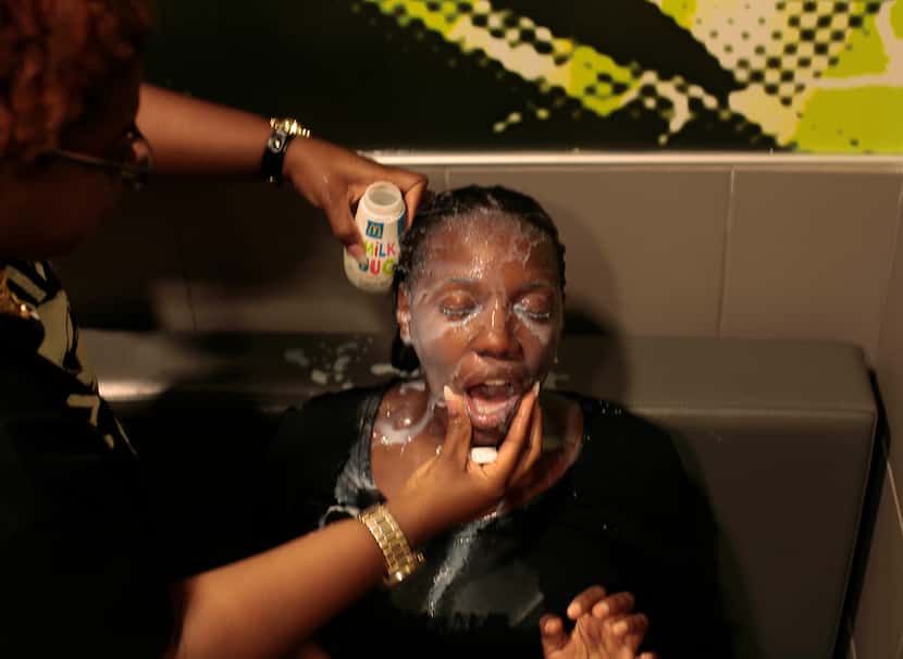 FERGUSON, MO - AUGUST 17:  A woman has her face doused with milk after suffering the effects...