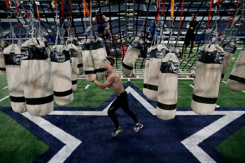 A racers maneuvers through punching bags during the Spartan Sprint race inside AT&T Stadium...