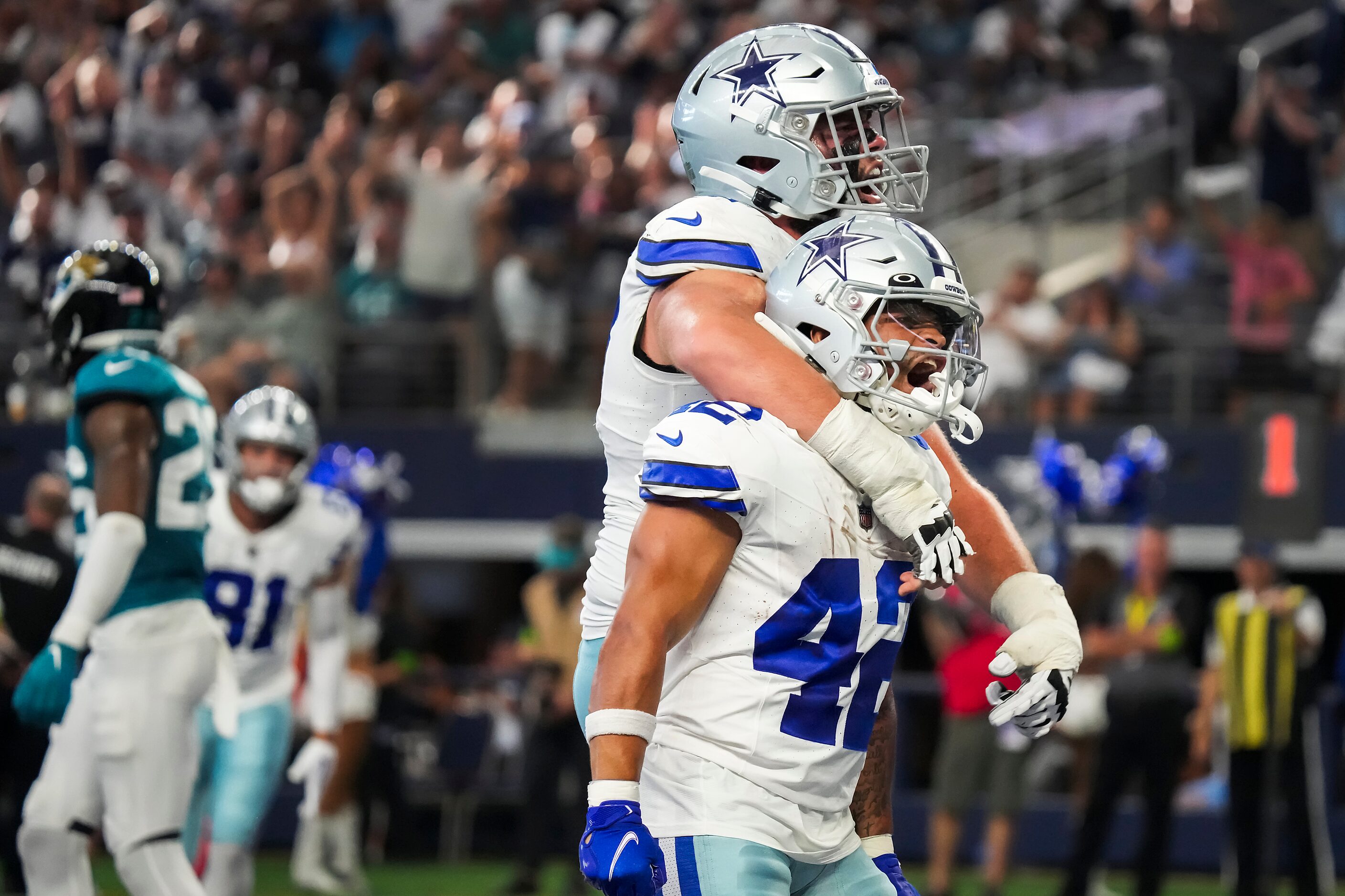 Dallas Cowboys running back Deuce Vaughn (42) celebrates with center Brock Hoffman (67)...