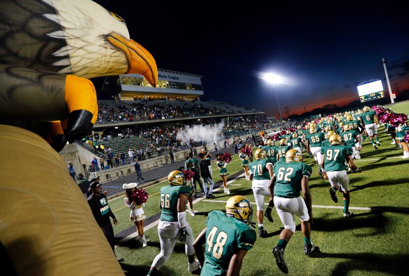 The DeSoto Eagles football team runs onto the field as they are introduced before their game...