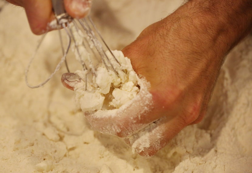 Chef Robert Lyford combines ingredients while preparing cheddar biscuits at Patina Green...