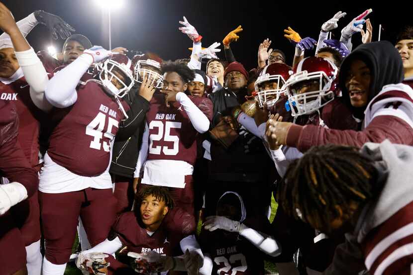 Red Oak High players celebrates their win against Denton High during a football game at...