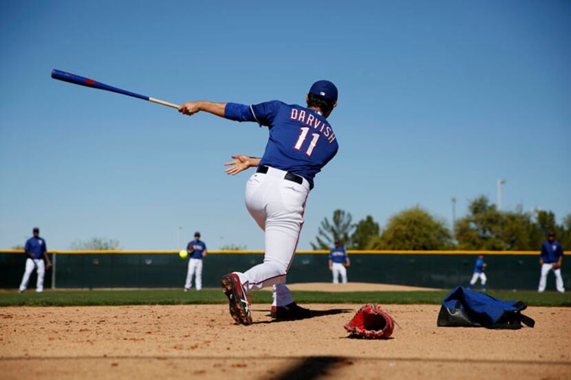  Texas Rangers pitcher Yu Darvish hits during a softball mock hitting and fielding game with...