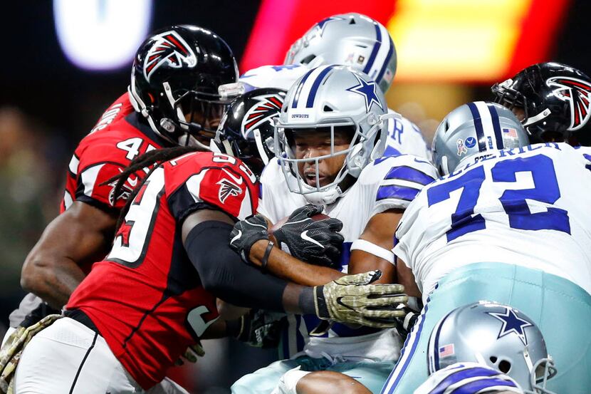 Dallas Cowboys running back Alfred Morris (46) is wrapped up by the Atlanta Falcons defense...