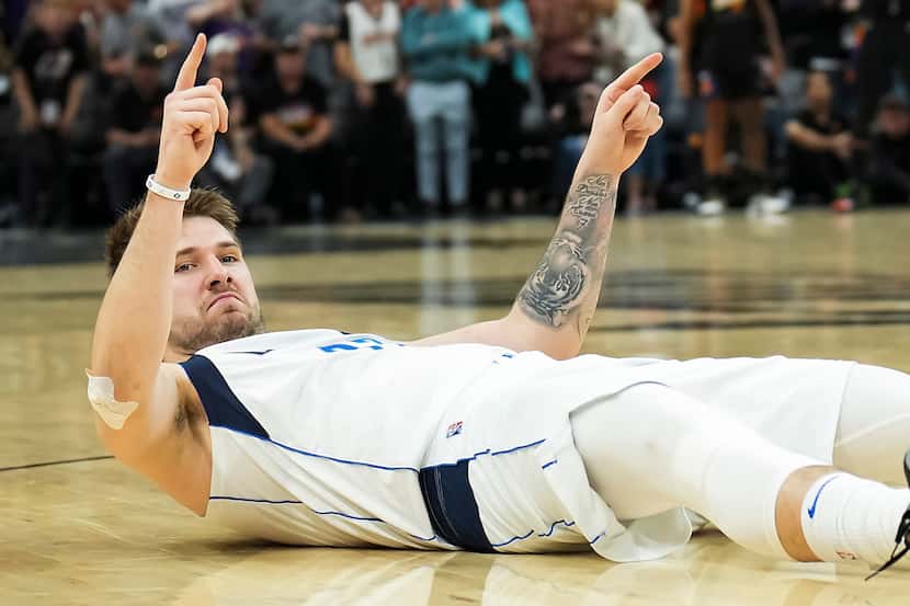 Dallas Mavericks guard Luka Doncic reacts after being knocked to the floor on a foul during...