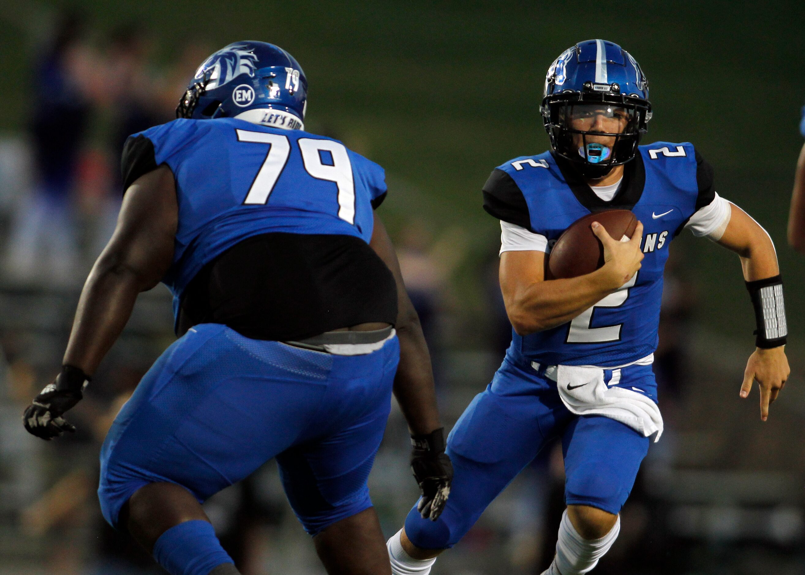 North Mesquite quarterback Luke Seder (2) takes off on a keeper behind the protection of...