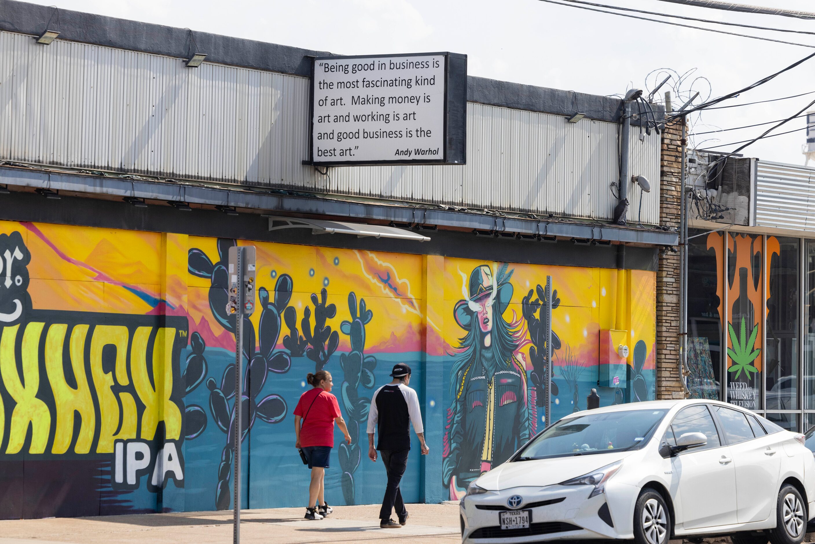 A quote by Andy Warhol hangs over a building in the Deep Ellum district of Dallas on Friday,...