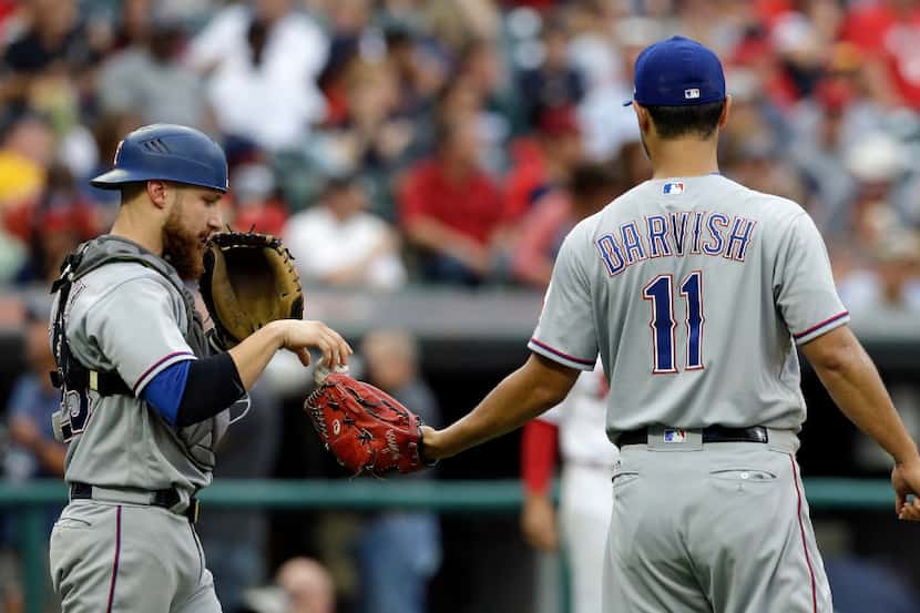 Texas Rangers starting pitcher Yu Darvish gets a ball from catcher Jonathan Lucroy in the...