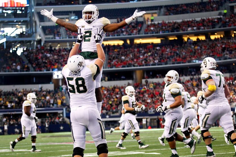 Baylor Bears running back Johnny Jefferson (2) is hoisted into the air by teammate Spencer...