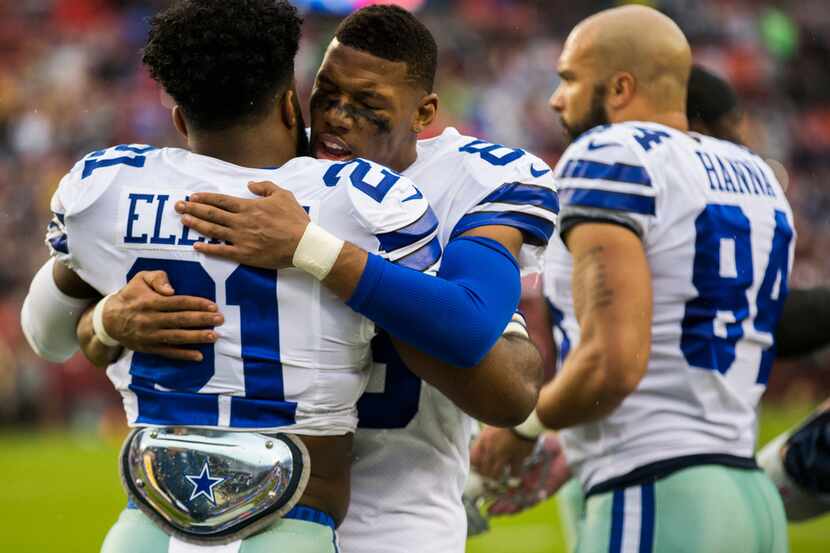 Dallas Cowboys running back Ezekiel Elliott (21) gets a hug from wide receiver Terrance...