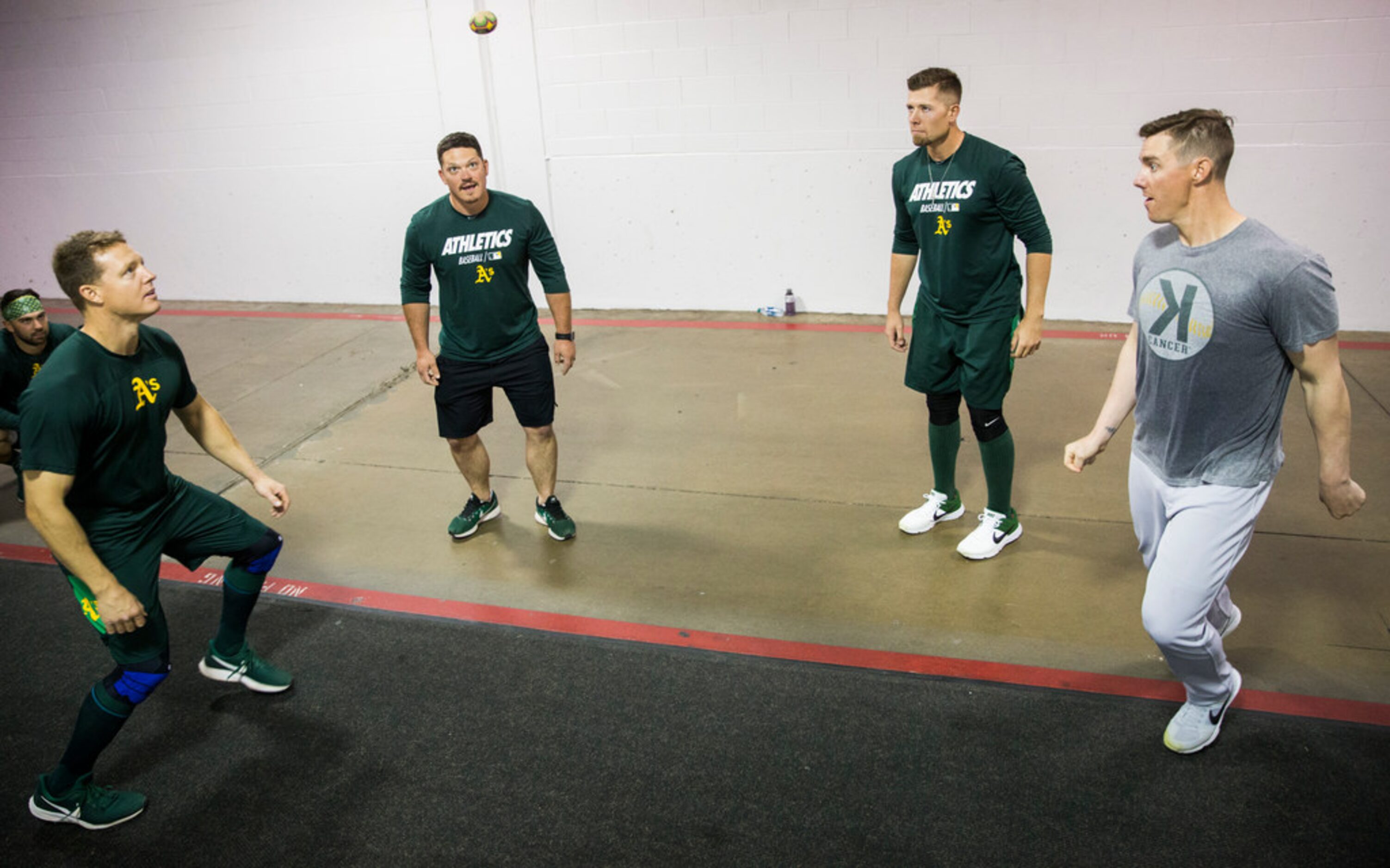 Oakland Athletics players play hacky sack in the tunnel during a rain delay at an MLB game...