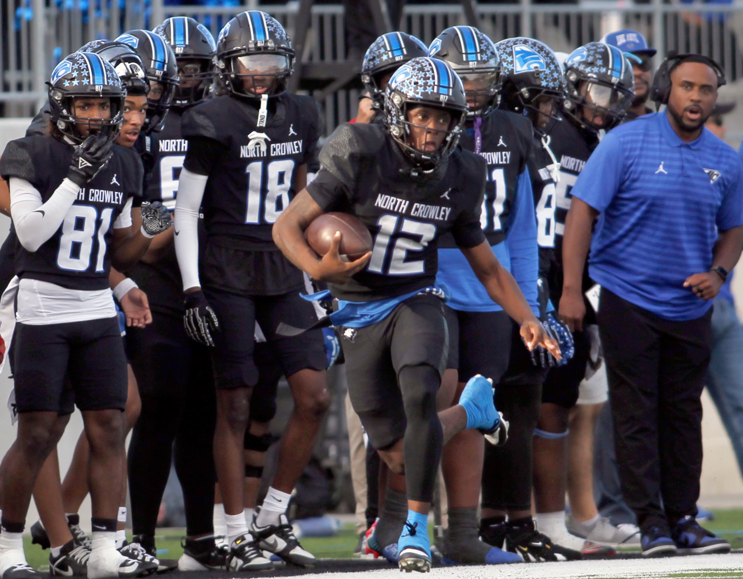 North Crowley quarterback Chris Jimerson,Jr. (12), center, runs past the team bench during a...