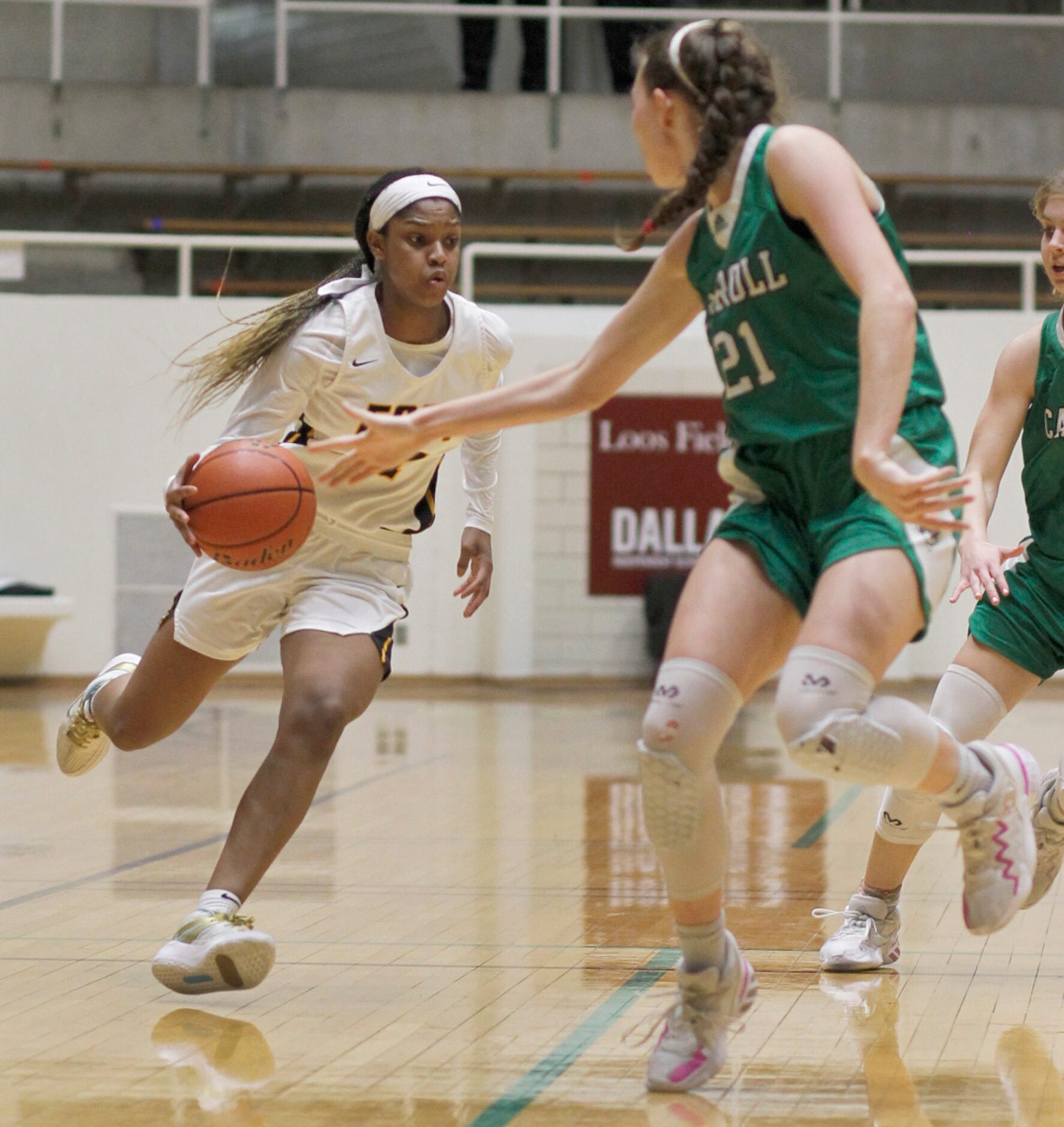 Plano East guard Kayla Cooper (11) cuts inside the defense of Southlake Carroll guard Kylie...