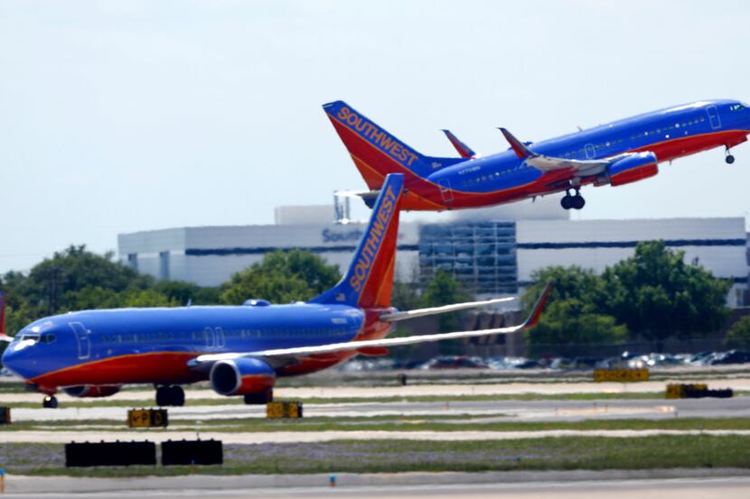 A Southwest Airlines jet takes off in front of company headquarters at Dallas Love Field in...