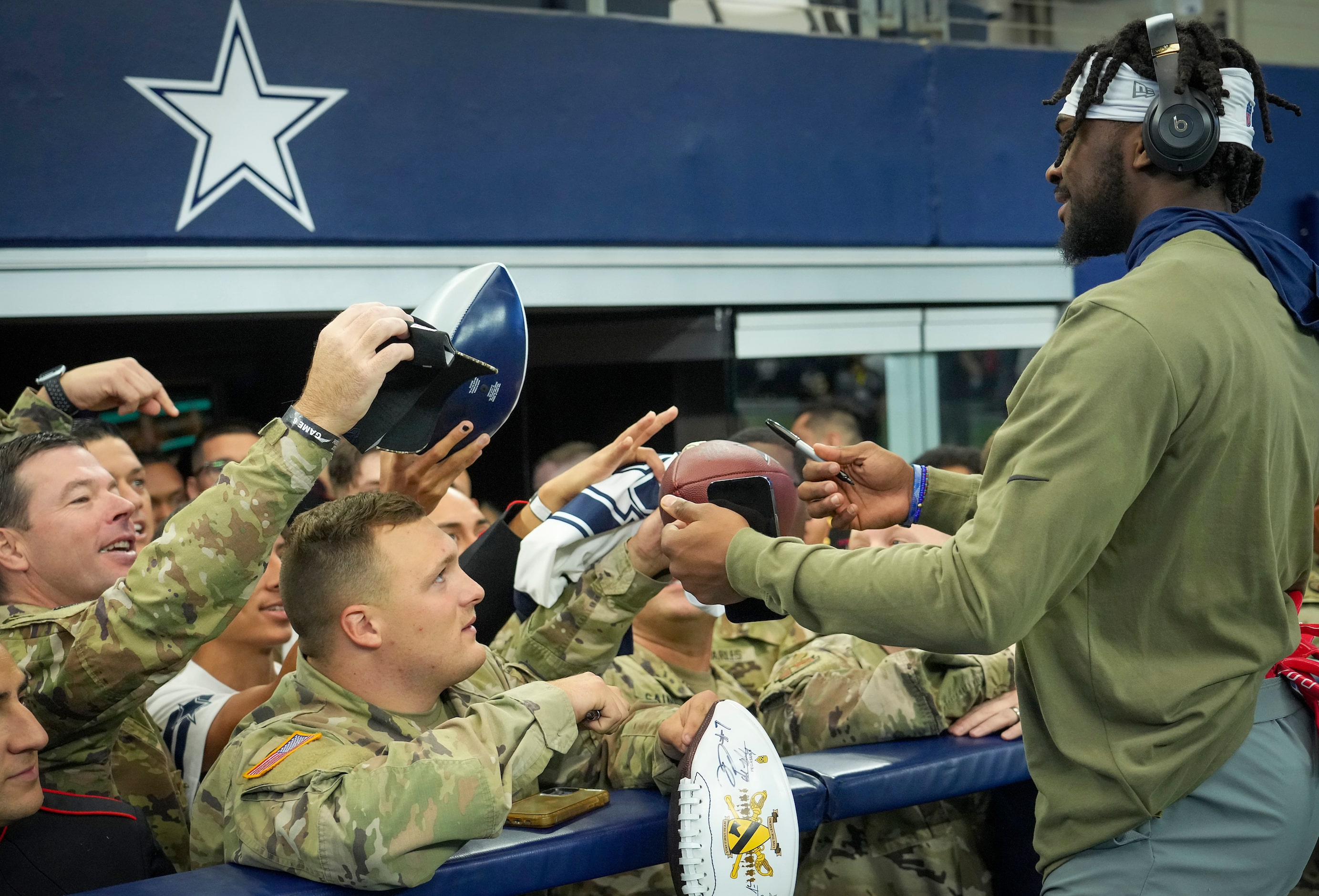 Dallas Cowboys defensive back Trevon Driggs signs autographs for a group of service members...