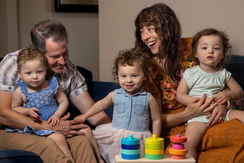 Chris Hury (left) and Allison Pistorius play with their 2-year-old triplet daughters, Birdie...