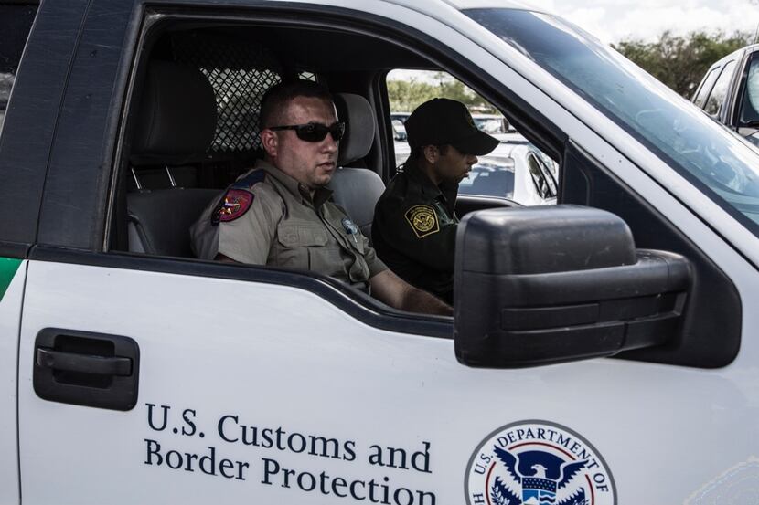 A Texas Department of Public Safety trooper rides with a U.S. Border Patrol agent in a...