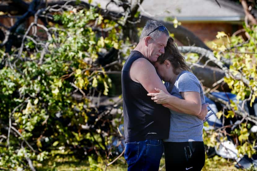 Tommy Edmonds, left, embraces his wife, Heidi Edmonds outside of their home, which was...