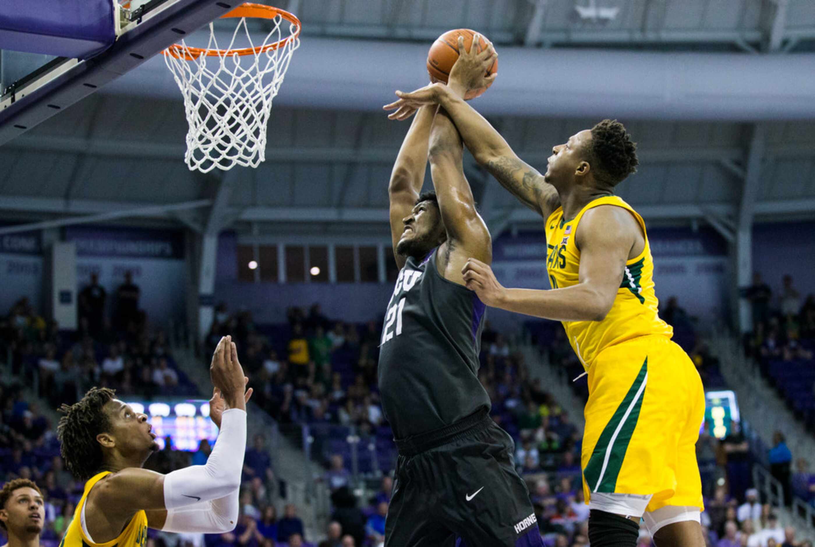 TCU Horned Frogs center Kevin Samuel (21) is fouled by Baylor Bears guard Mark Vital (11)...