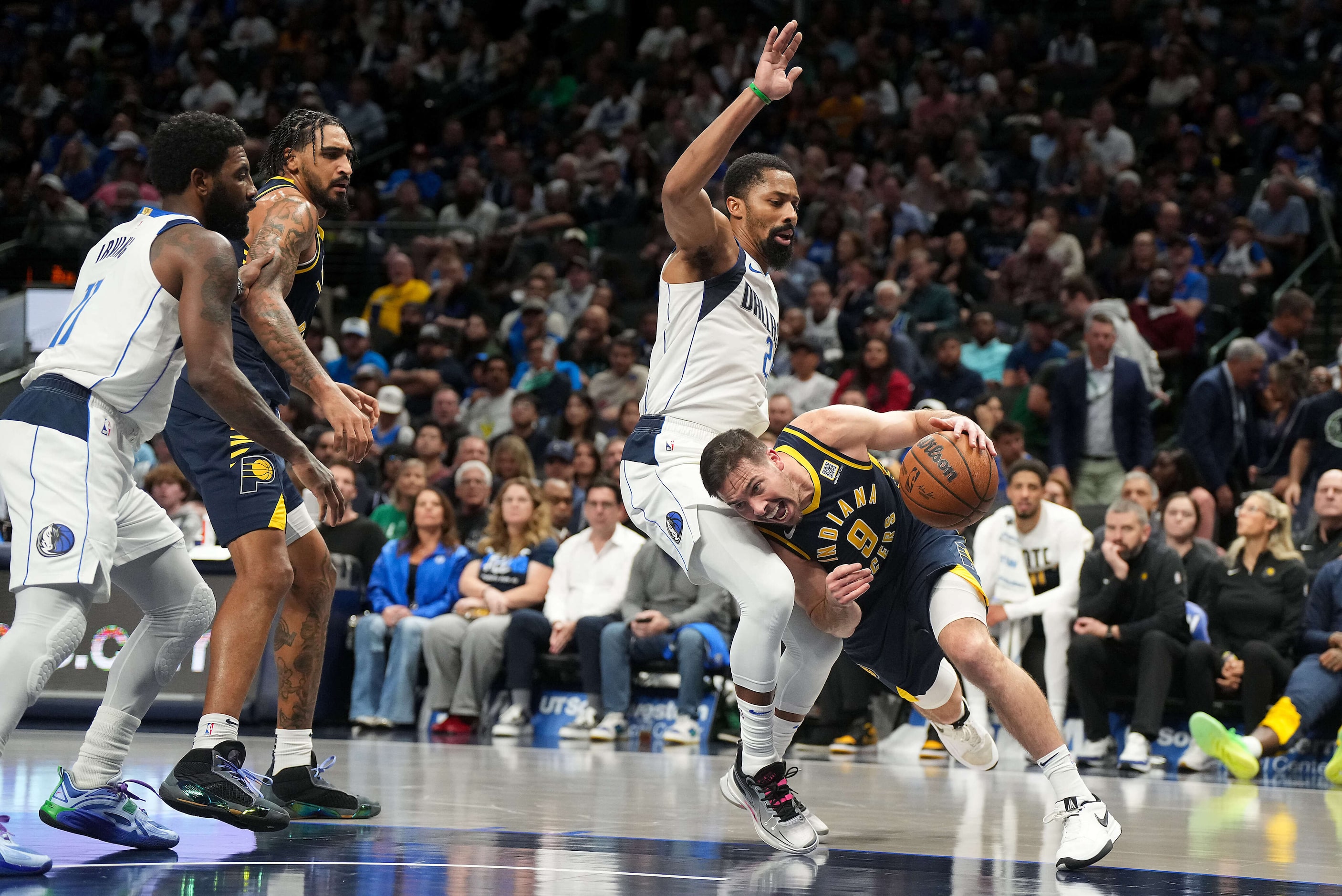 Indiana Pacers guard T.J. McConnell (9) drives to the basket around Dallas Mavericks guard...