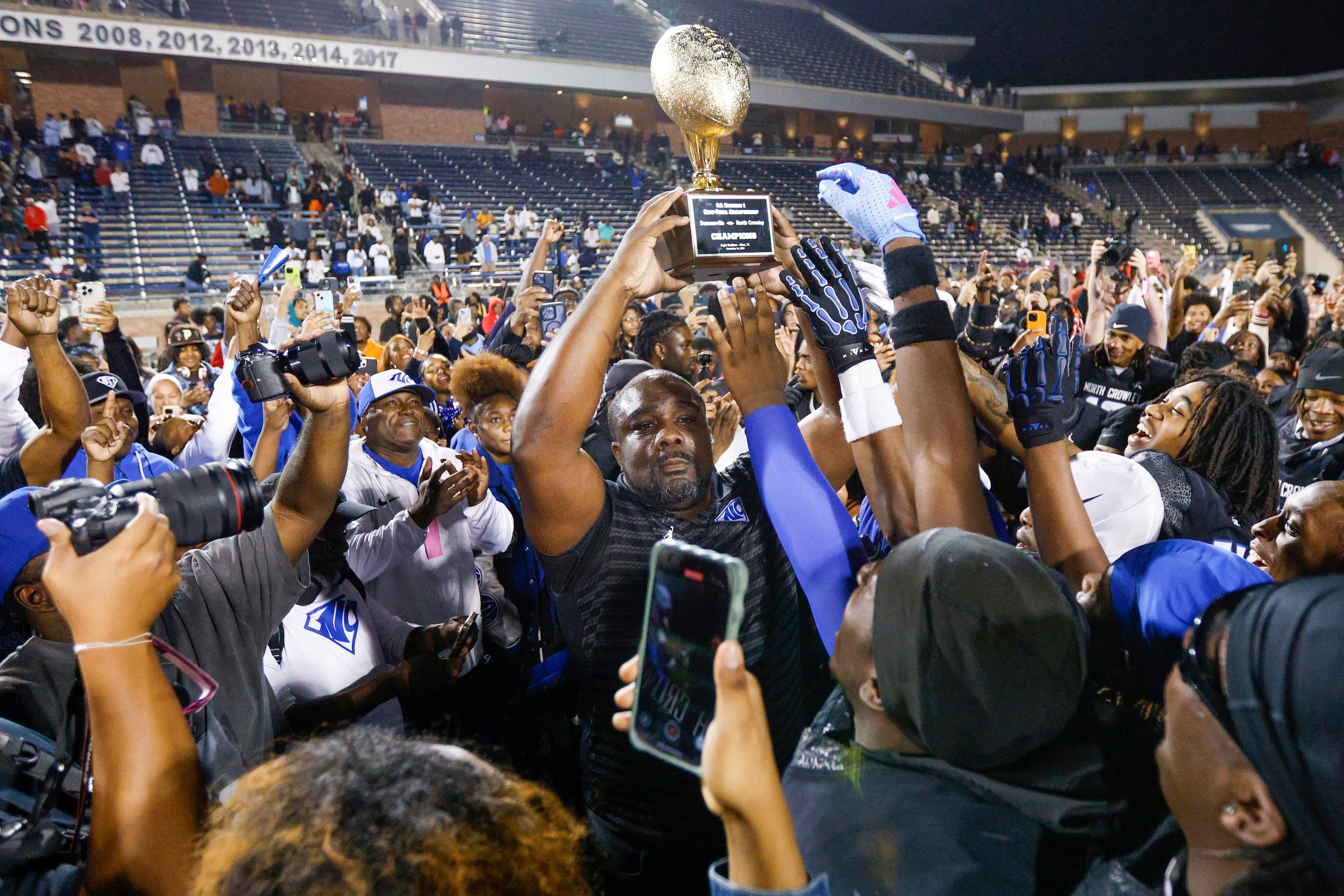 North Crowley head coach Ray Gates raises a Class 6A Division I state semifinal championship...