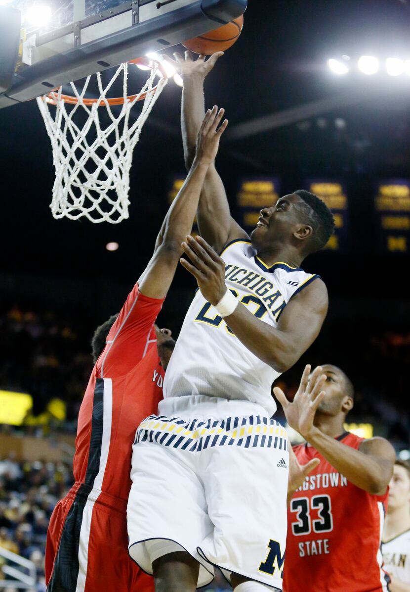 Caris LeVert #23 of the Michigan Wolverines goes to the basket against Cameron Morse #24 of...