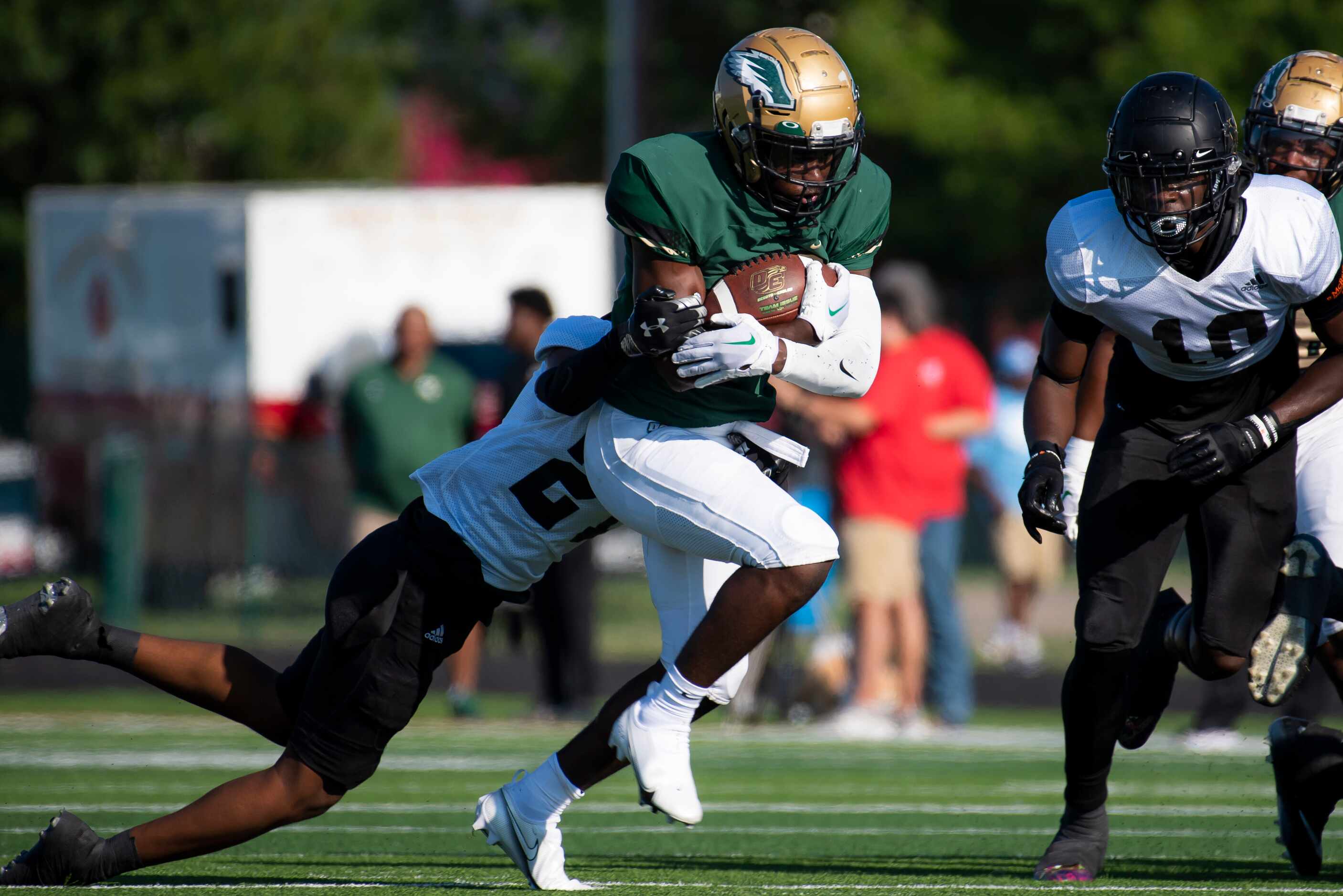 DeSoto sophomore Deondrae Riden Jr. (22) rushes with the ball as he is tackled by South Oak...