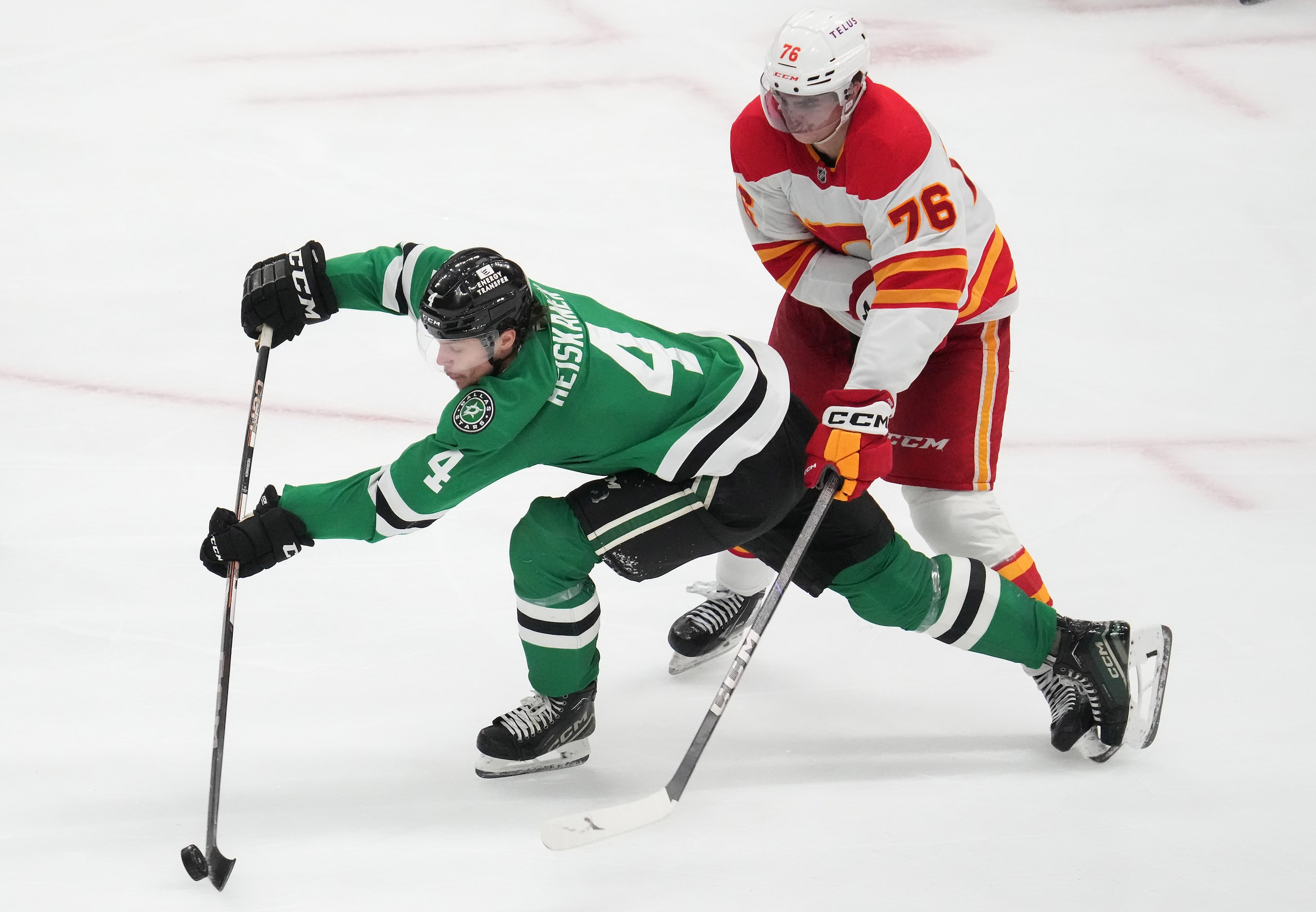 Dallas Stars defenseman Miro Heiskanen (4) clears the puck from Calgary Flames center Martin...