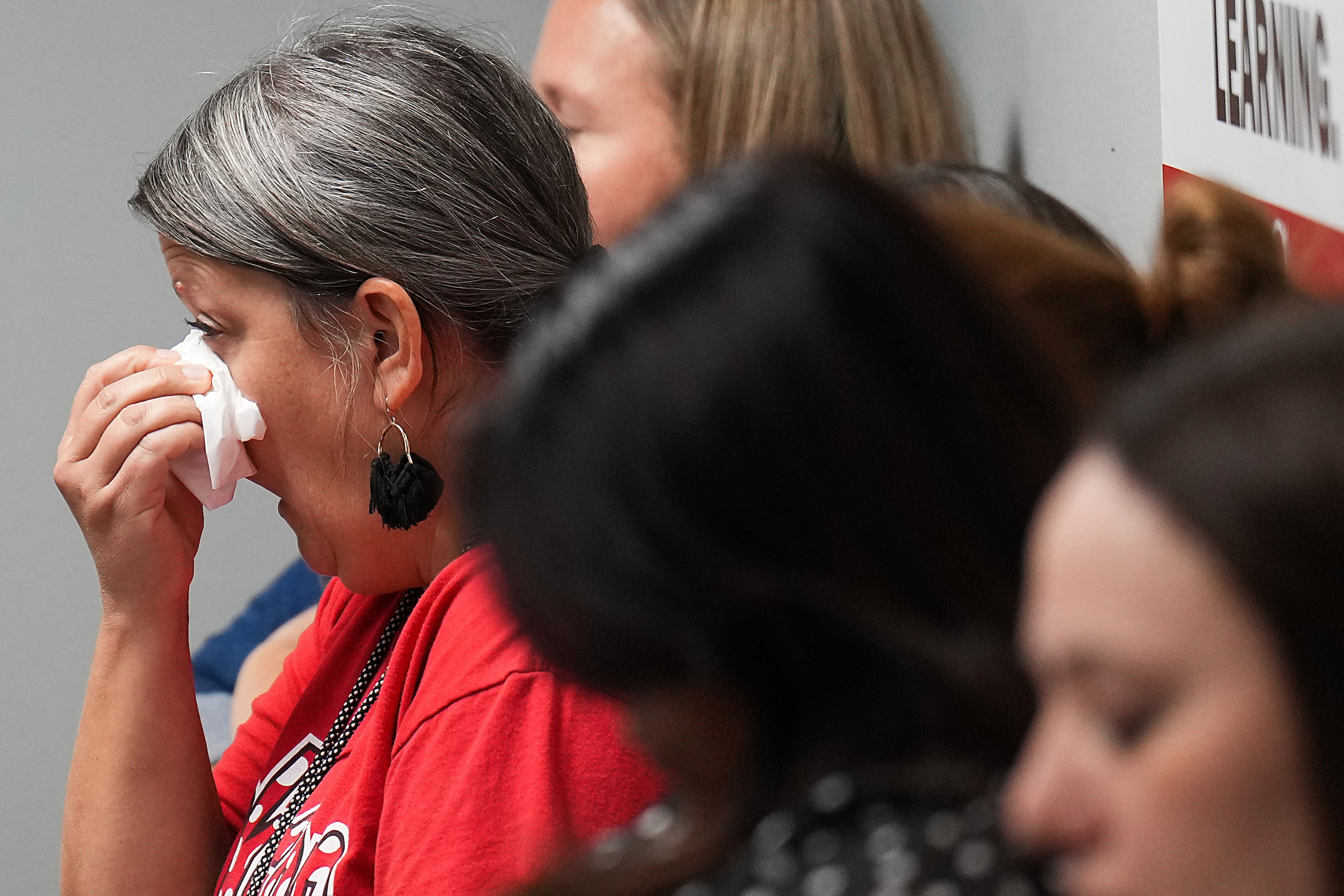 A woman in the audience wipes away tears during the Coppell ISD school board meeting on...