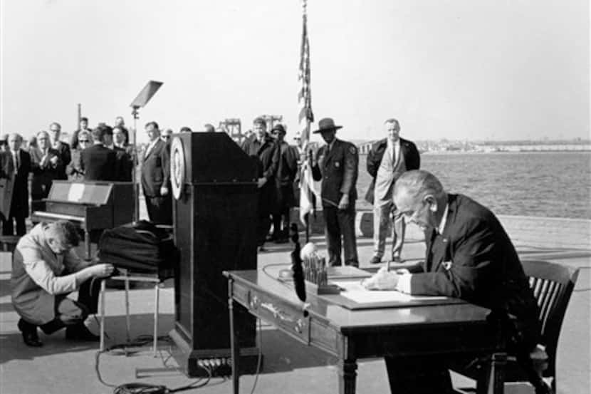 Lyndon B. Johnson firma ley migratoria  de 1965 en Liberty Island.
AP
