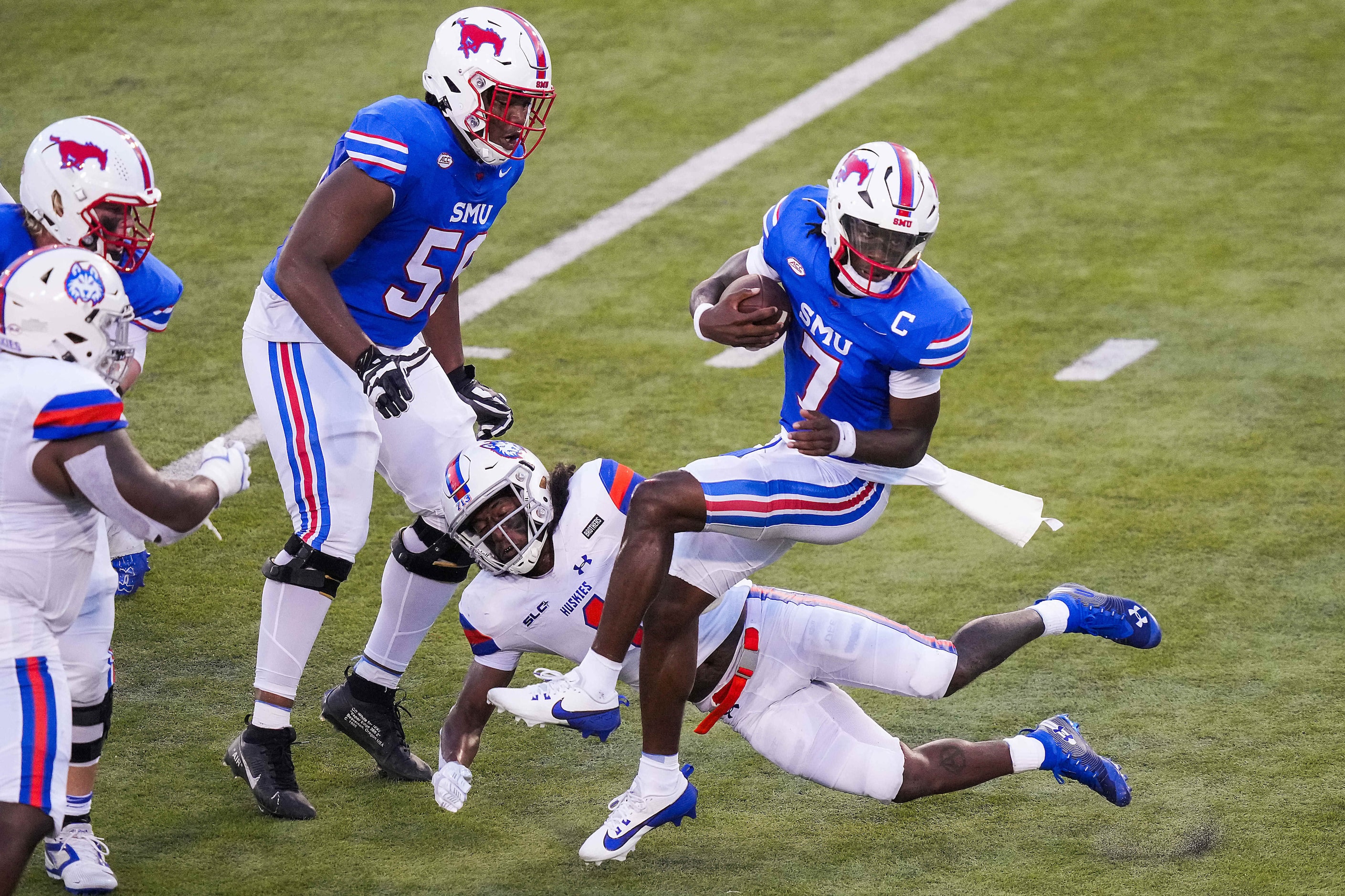 SMU quarterback Kevin Jennings (7) spins away from Houston Christian safety Xavier Toliver...