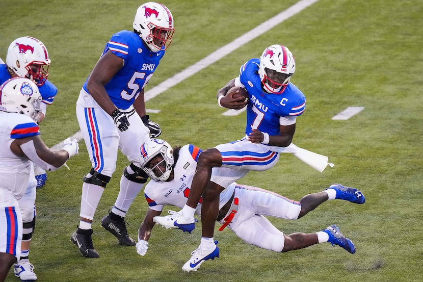 SMU quarterback Kevin Jennings (7) spins away from Houston Christian safety Xavier Toliver...