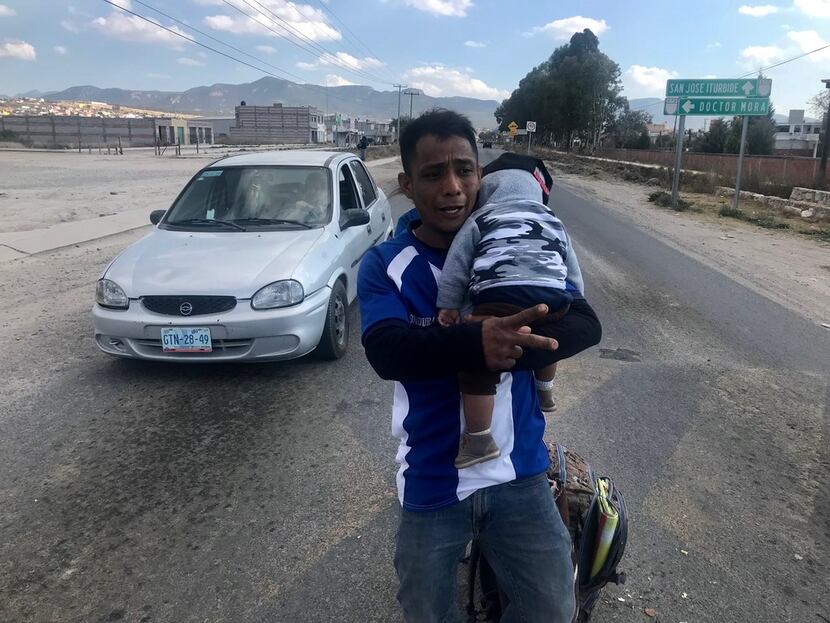 Jonathan David Cardenas, 32, with 8-month-old son Julio Cesar, walked along a main...