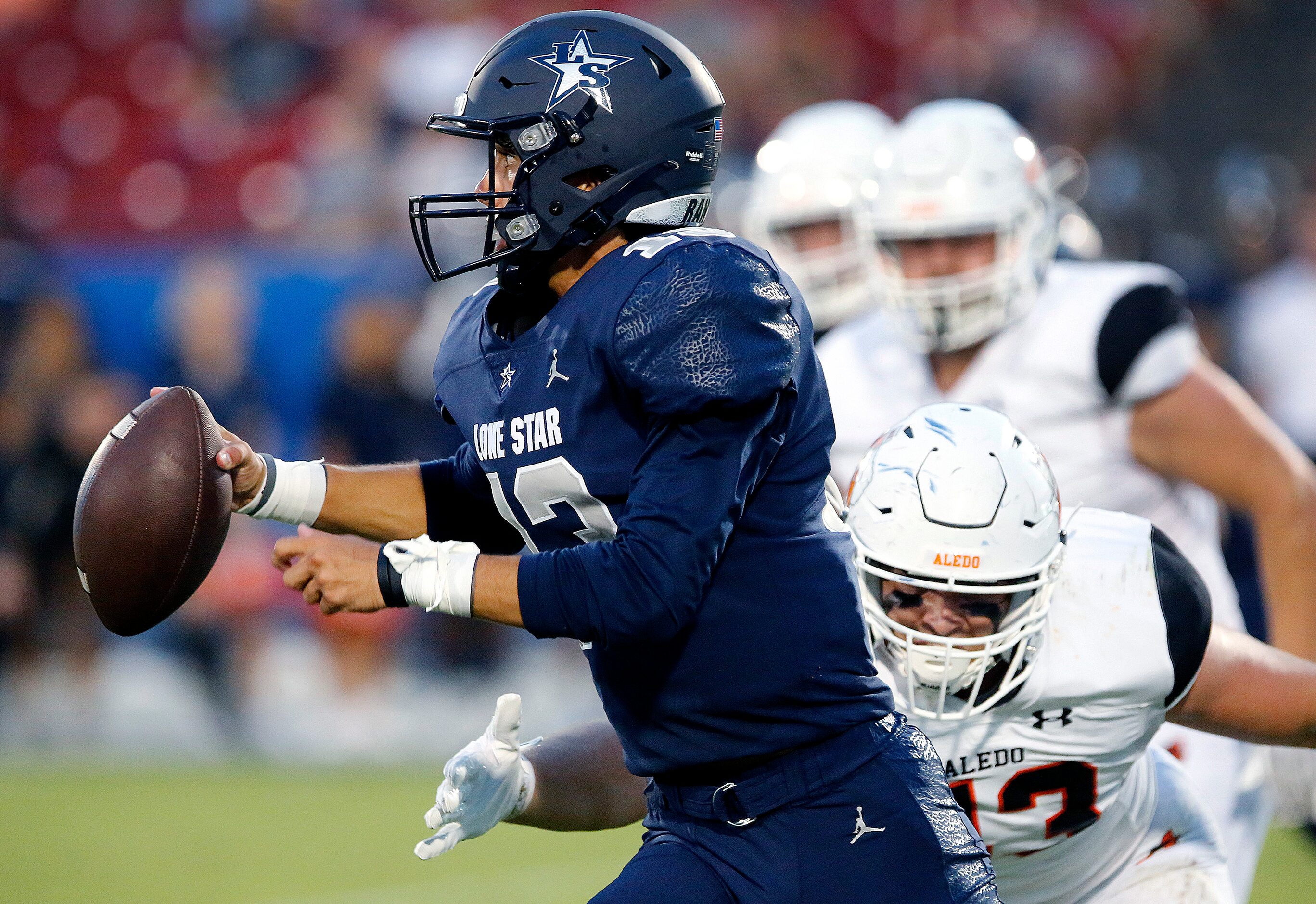 Lone Star High School quarterback Garret Rangel (13) runs away from Aledo High School...