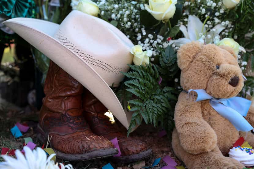 Boots and a hat sit at Xavier Gonzalez’s grave Sunday in Garland, Texas. 