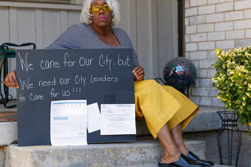 Jill Mitchell poses for a portrait holding a sign she intended to create to take part in a...