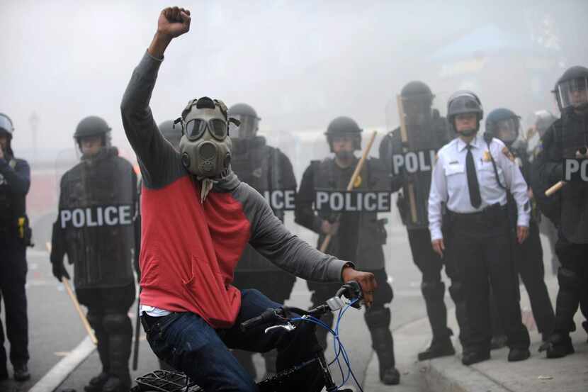 On Monday,  a protester rode his bike in front of police in riot gear   at North and...