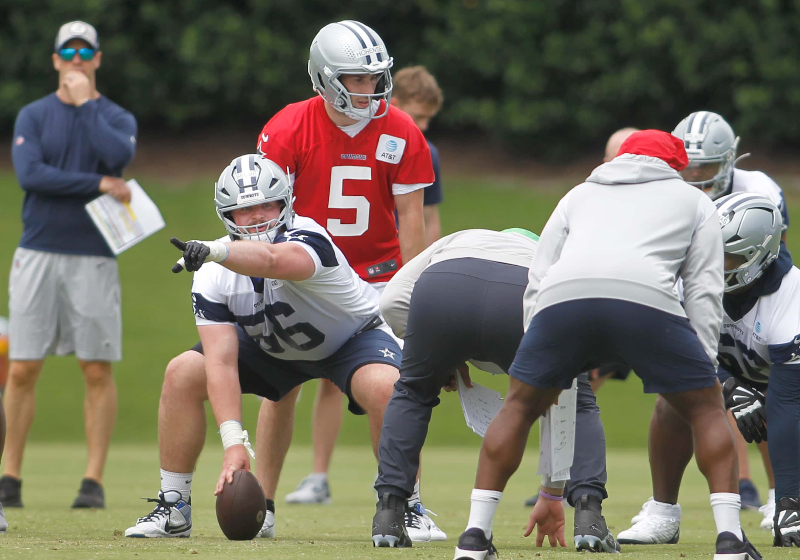 Dallas Cowboys offensive lineman Cooper Beebe (56), lower left,  simulates his communication...