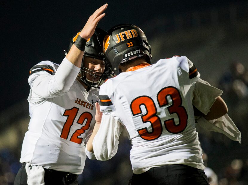 Rockwall quarterback Jacob Clark (12) celebrates with fullback Carson Sargent (33) after...