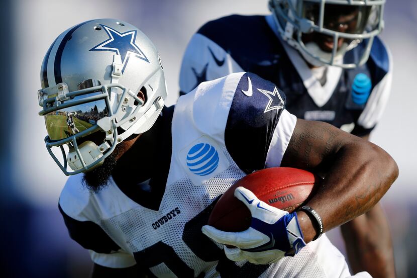 A defender is reflected in Dallas Cowboys wide receiver Dez Bryant's visor as he shakes...