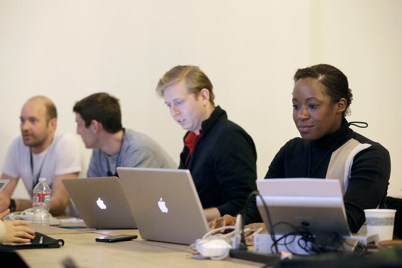 In this Saturday, Feb. 8, 2014 photo, Fanya Young, right, and other participants work on...