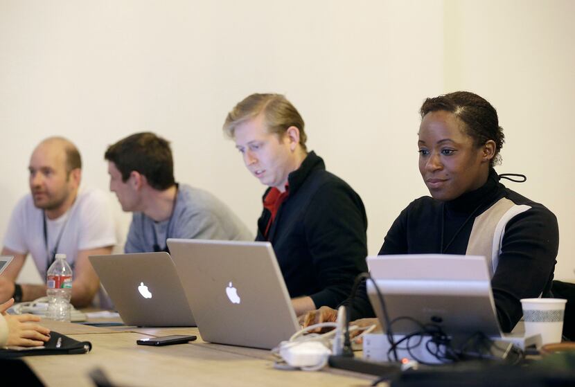 In this Saturday, Feb. 8, 2014 photo, Fanya Young, right, and other participants work on...