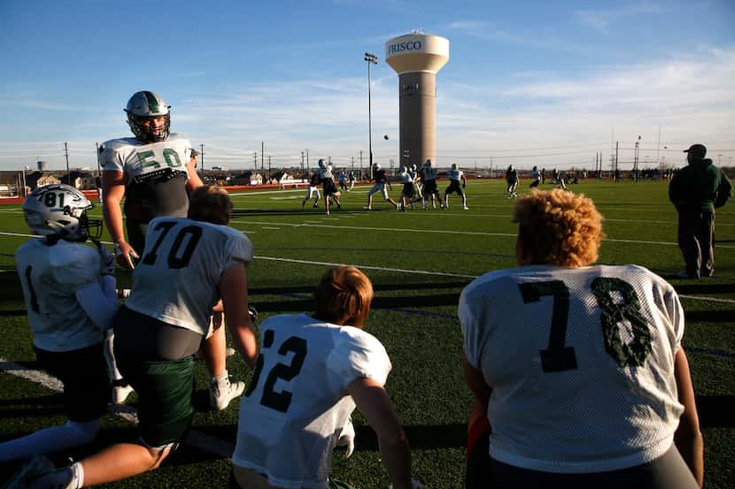 Players rest on the sidelines during practice at Rick Reedy High School in Frisco. Frisco...