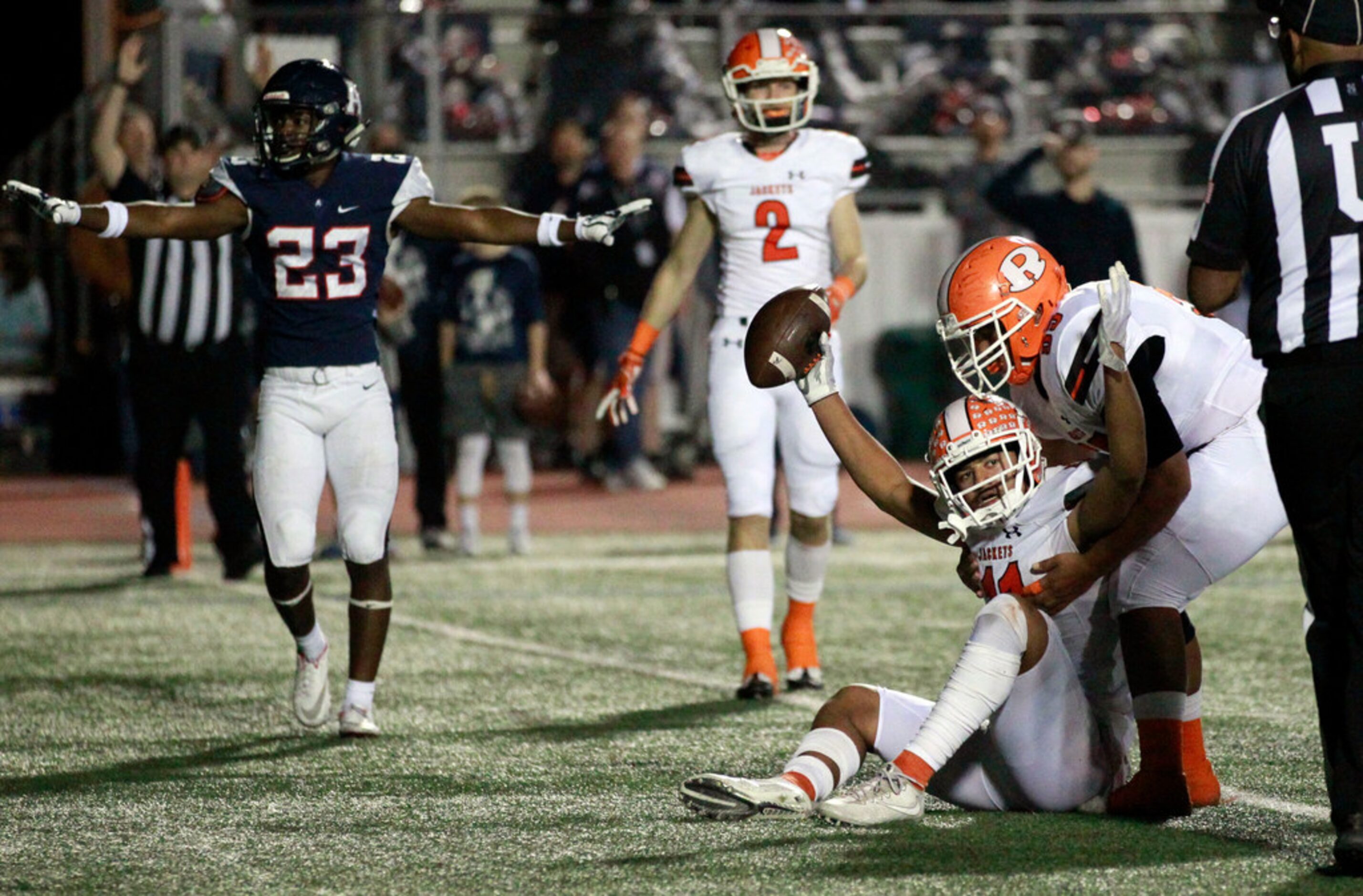 Rockwall's Jaxon Smith-Njigba (11) holds the ball high, but Allen's Mo Perkins (23) say no,...