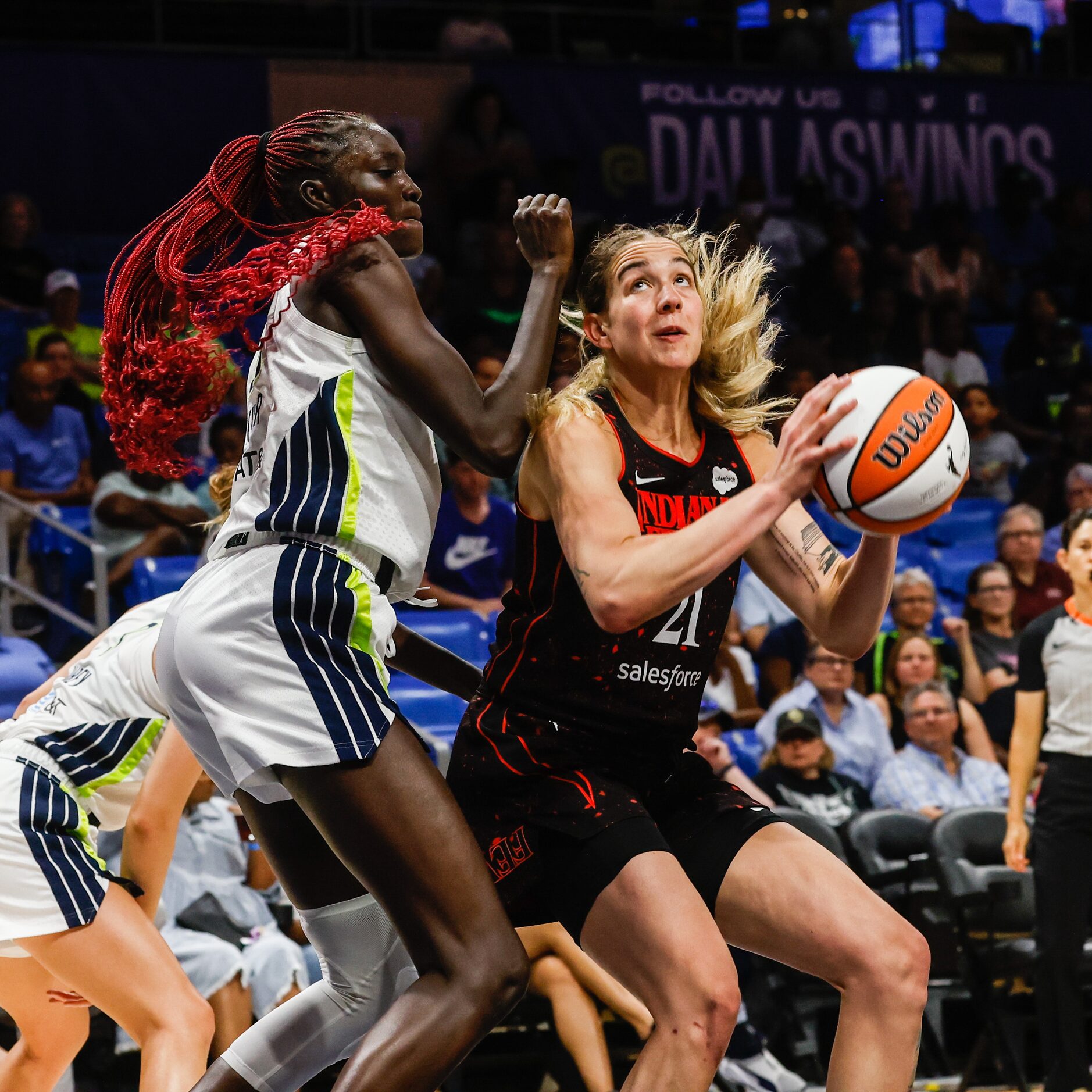 Indiana Fever forward Emily Engstler (21) goes for a shot as Dallas Wings center Awak Kuier...