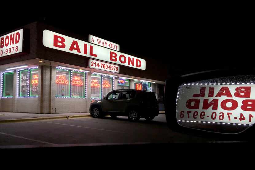 Lights from a bail bond business glow in the darkness along Riverfront Boulevard in Dallas...