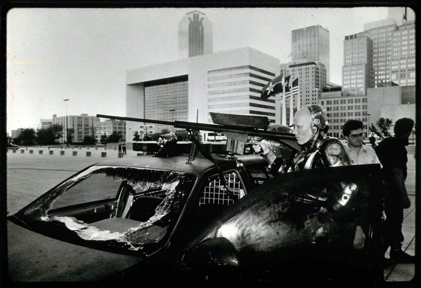 The Dallas skyline looms behind actor Peter Weller during a filming of RoboCop outside...
