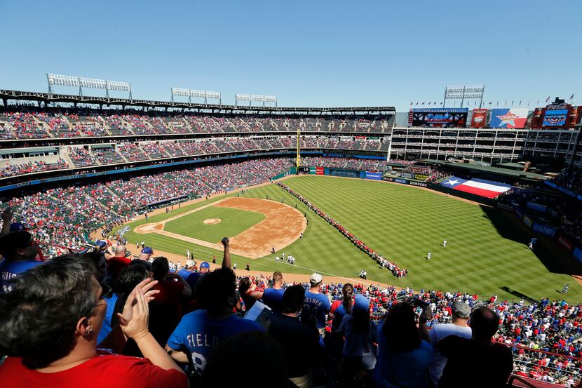Texas Rangers fans celebrate as the teams are about to be introduced before a game between...