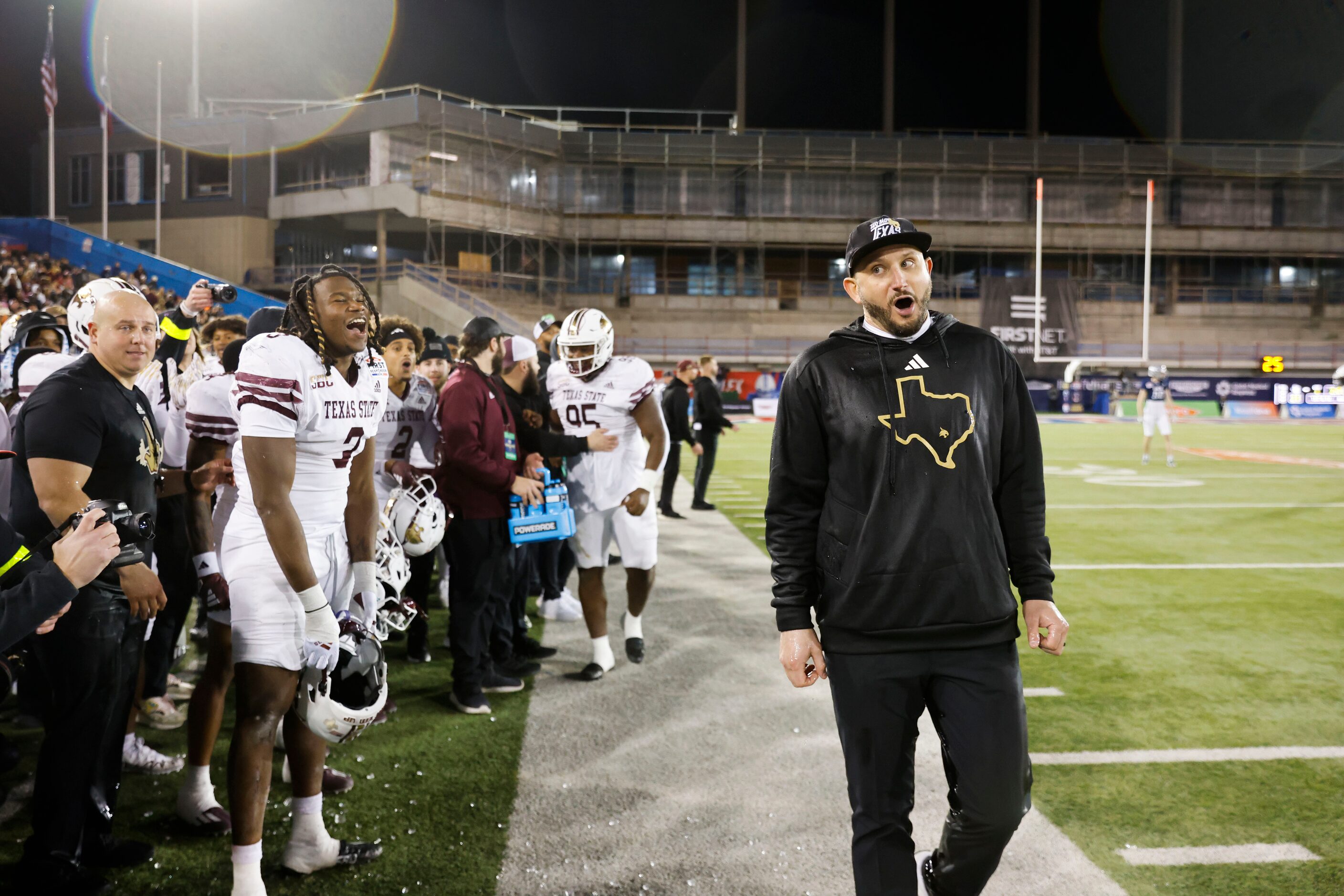 Texas State head coach GJ Kinne reacts towards the players as he is doused by water ahead of...