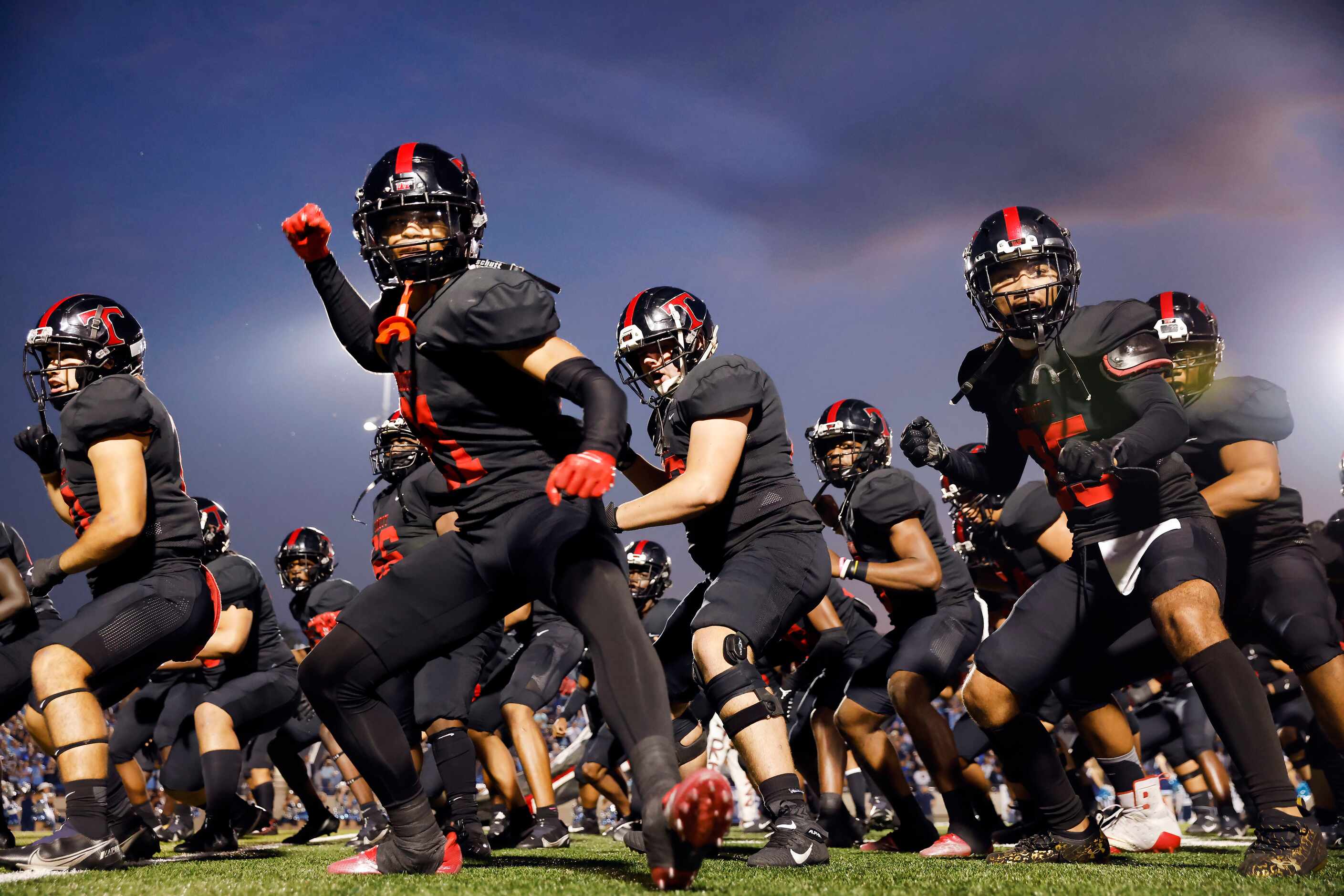 Euless Trinity football players, including Tyson Thomas (21, center) and Jessie Bosier (35),...